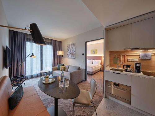 科隆Adina Apartment Hotel Cologne的厨房以及带桌子的客厅。