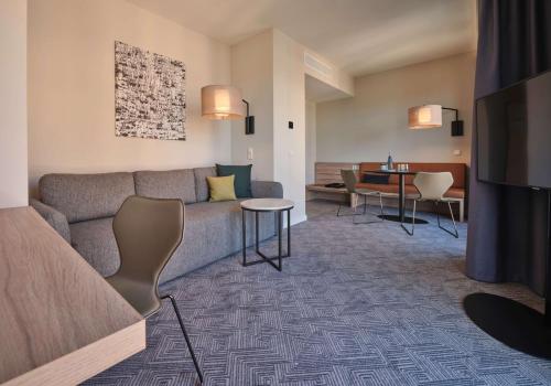 科隆Adina Apartment Hotel Cologne的客厅配有沙发和桌子