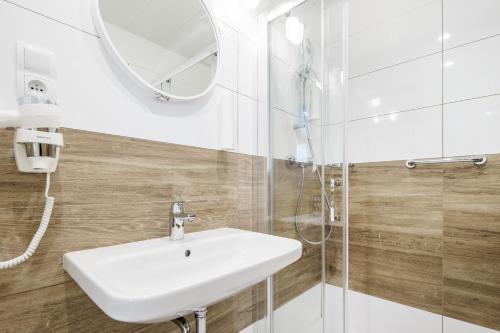 尤斯托尼莫斯基VacationClub - Boulevard Residence Apartament 11的浴室设有白色水槽和镜子
