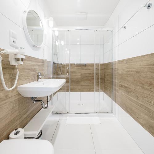 尤斯托尼莫斯基VacationClub - Boulevard Residence Apartament 11的带淋浴和盥洗盆的浴室