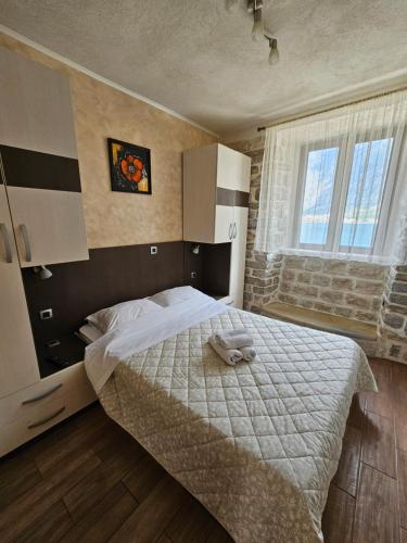 科托尔灯笼塔公寓的一间卧室配有一张带白色毯子的床和窗户。