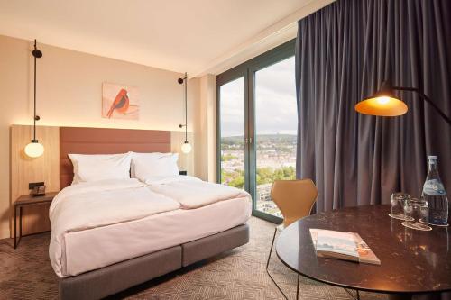 斯图加特Adina Apartment Hotel Stuttgart的酒店客房配有一张床铺和一张桌子。