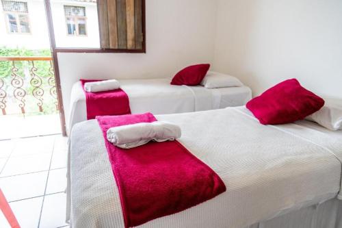 奥林达普萨达波巴酒店的宿舍间内的两张床,配有红色和白色毛巾