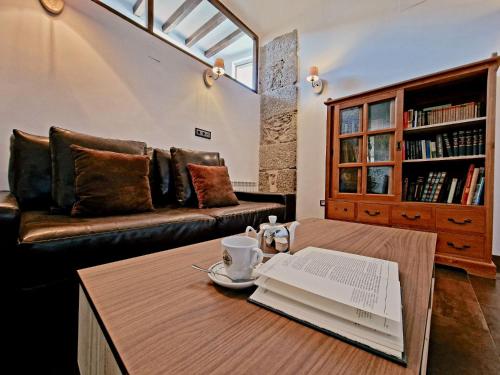 皮尔托贝加Hotel Rural Candela y Plata的客厅配有沙发和一张桌子及一本书