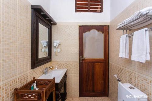 桑给巴尔米兹贾尼海滨酒店的一间带水槽、卫生间和镜子的浴室
