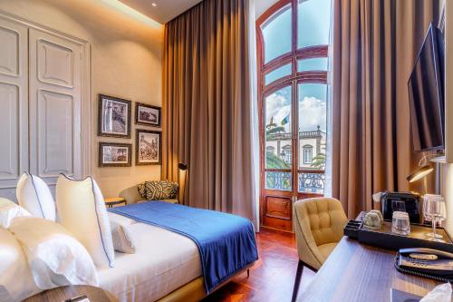 大加那利岛拉斯帕尔马斯Boutique Hotel Cordial Plaza Mayor de Santa Ana的配有一张床、一张书桌和一扇窗户的酒店客房