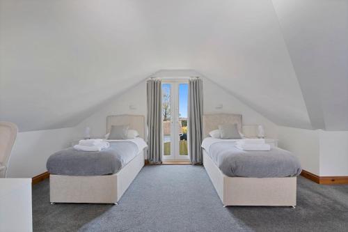 格雷夫森德Modern 8-Bed Home - Parking, Wi-Fi, 5 mins to Town的白色墙壁客房的两张床