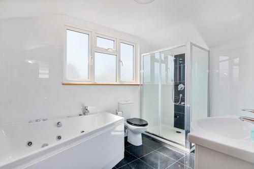 格雷夫森德Modern 8-Bed Home - Parking, Wi-Fi, 5 mins to Town的白色的浴室设有卫生间和水槽。