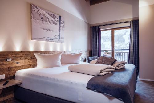萨尔巴赫Familienresort Ellmauhof - das echte All Inclusive的卧室设有一张白色大床和一扇窗户。