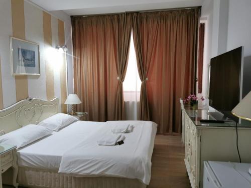 布加勒斯特Nevis Fundeni的卧室配有白色的床和电视。
