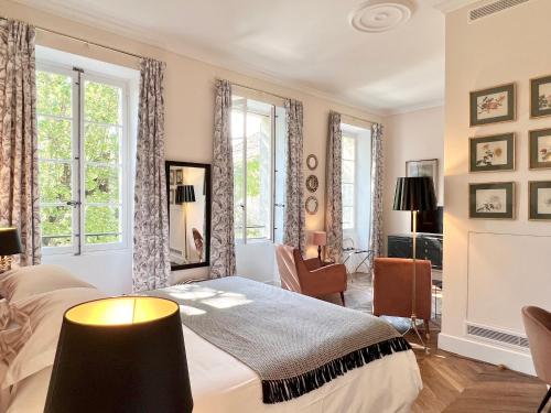阿维尼翁克洛斯萨卢塞斯旅馆的一间卧室设有一张床和两个窗户。