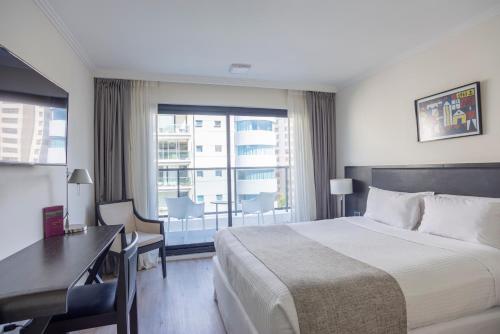 蒙得维的亚蒙得维的亚阿芙特酒店的配有一张床、一张书桌和一扇窗户的酒店客房
