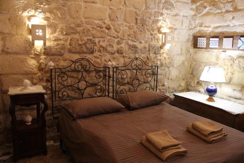 阿尔塔穆拉Malta & Tufo的一间卧室配有一张床,上面有两条毛巾