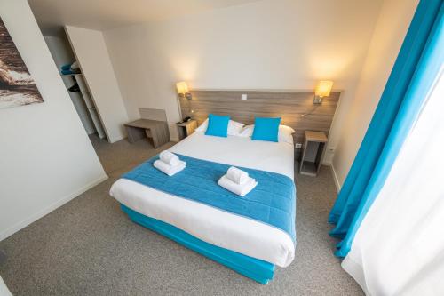 塞纳河畔诺让圣罗兰酒店的一间卧室配有一张带蓝色枕头的大床