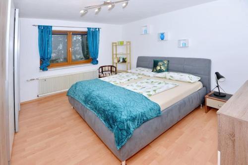 BachFerienwohnung Karawankenblick的一间卧室配有一张带蓝色毯子的大床