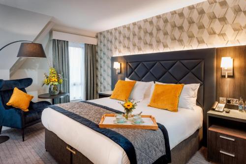 都柏林卡姆登科特酒店的酒店客房配有一张带黄色枕头的大床