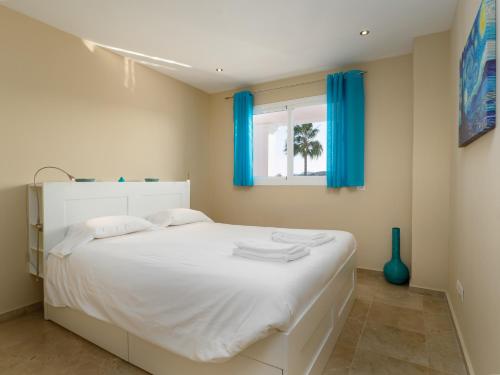 马尼尔瓦2174-Huge 3 bedrooms with terrace and pool的卧室配有一张带蓝色窗帘的大型白色床