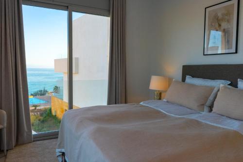 福恩吉罗拉Villa Palm Beach - Incredible villa with 5 rooms, amazing sea view and private pool的一间卧室设有一张床和一个大窗户