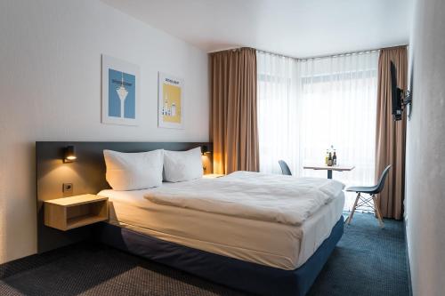 杜塞尔多夫Apartments an der Kö的酒店客房设有一张大床和一张书桌。
