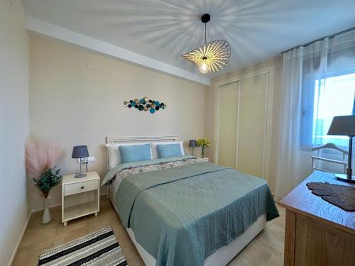 卡尔佩Esmeralda Suites 21º piso的一间卧室配有一张床和一个吊灯