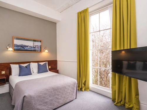布里斯托克利夫顿华盛顿酒店的一间卧室设有一张床和一个大窗户