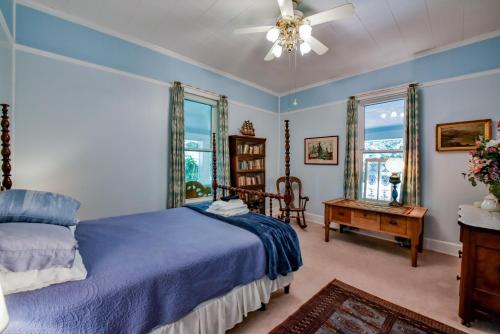 塔斯卡卢萨Firefly Garden的一间卧室配有一张蓝色的床和一张桌子