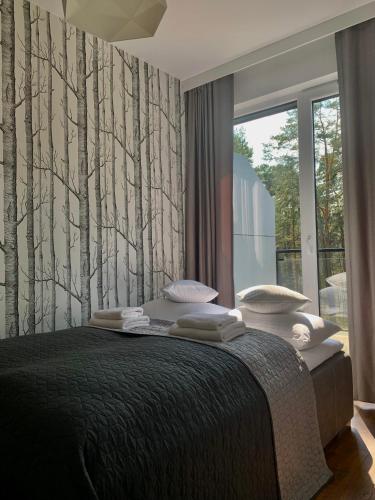 奥古斯图REMAR - Apartamentai prie Necko Ežero的卧室配有一张墙上树木环绕的床