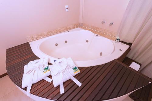 约恩维利Hotel Fazenda Dona Francisca的带浴缸和2条毛巾的浴室