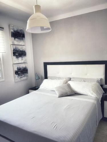 科拉雷侯LOS DELFINES的卧室配有一张大白色的床和大床头板