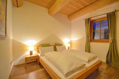 滨湖采尔Chalet Stabler - by Alpen Apartments的一张位于带两盏灯和一扇窗户的房间的床铺