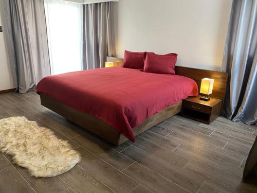 圣斐利-银港Picturesque Ocean View Condo的一间卧室配有一张带红色床罩和地毯的床。