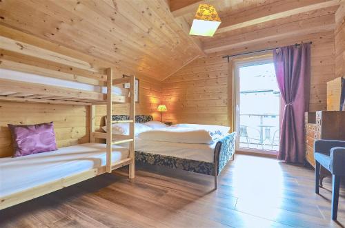 滨湖采尔Chalet Seven - by Alpen Apartments的木制客房设有两张双层床和窗户。
