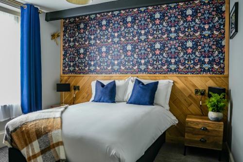 索尔兹伯里老磨房酒店的一间卧室配有一张带花卉壁纸的大床