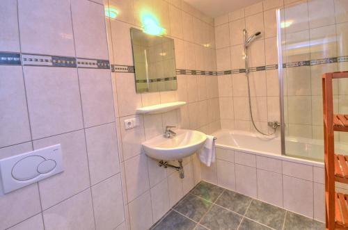 滨湖采尔Apartment Golfski - by Alpen Apartments的白色的浴室设有水槽和淋浴。
