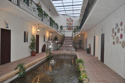 TararameoMia Bonita Hotel Boutique的大楼中央带池塘的走廊
