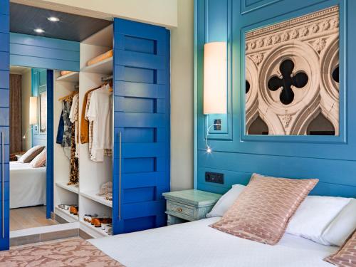 阿德耶阿德里安科隆瓜纳哈尼成人酒店的蓝色卧室配有一张床和一个衣柜