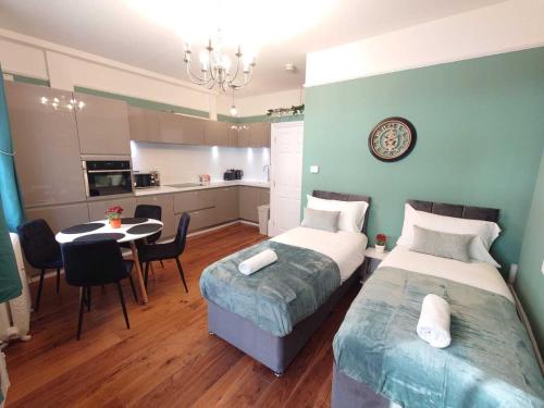 伦敦Kings Cross Apartment的一间带两张床和一张桌子的卧室以及一间厨房