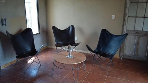 Pueblo CentenarioCasa en Pueblo Centenario的三个黑椅子和一张桌子