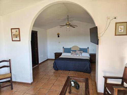 TorilHotel Rural Portilla de Monfragüe的一间卧室配有一张床和吊扇
