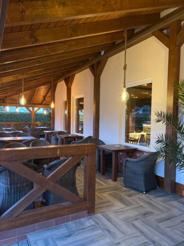 奥得河畔法兰克福Hotel Rosengarten的用餐室配有木桌和椅子