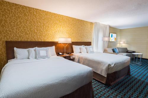 安卡斯维尔Fairfield by Marriott Inn & Suites Uncasville Mohegan Sun Area的酒店客房,配有两张床和椅子