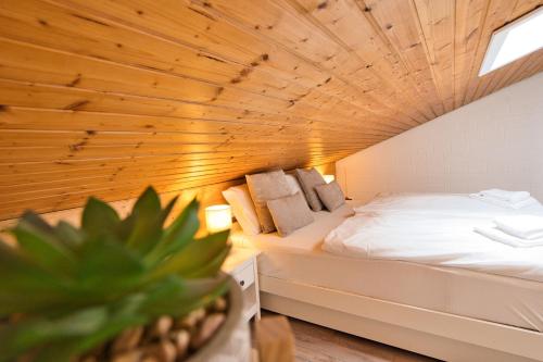 圣安德里斯伯格Traumblick的一间卧室设有一张床和木制天花板