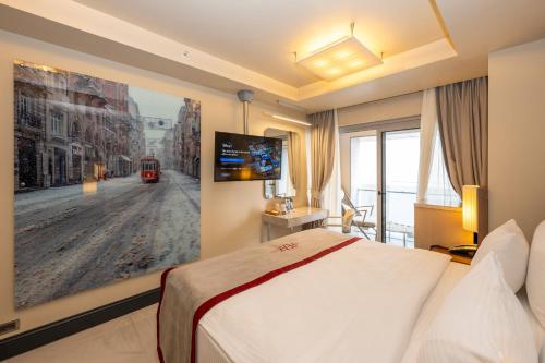 伊斯坦布尔Ramada By Wyndham Istanbul Pera Taksim的酒店客房设有一张床,墙上挂有绘画作品