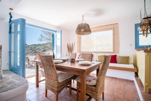 纳乌萨Kolimpithres beach house的一间带桌椅和沙发的用餐室