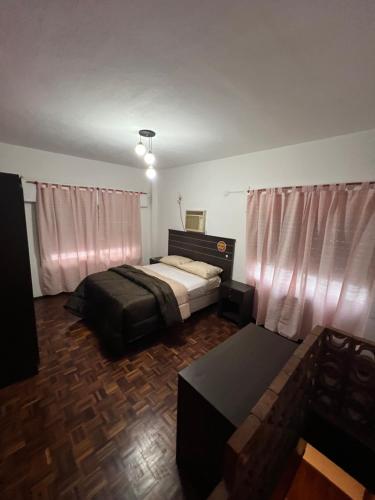 罗萨里奥El pasillo Centro的一间卧室配有一张床、一张桌子和窗帘