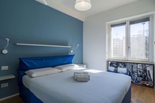 米兰Easylife - Accogliente appartamento in Bocconi的蓝色的卧室设有一张大白色的床和窗户