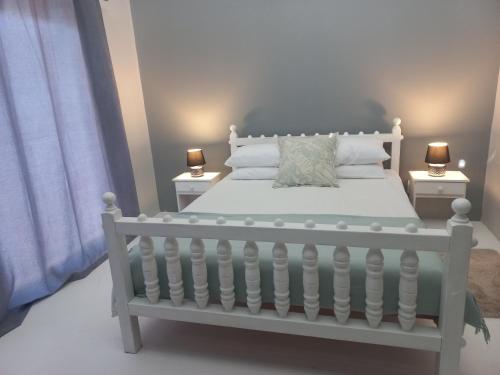 赫曼努斯Kwikstertjie的卧室配有带两盏灯的白色床