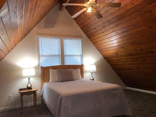 海恩尼斯Courtyard Resort的一间卧室配有一张带吊扇和两盏灯的床。