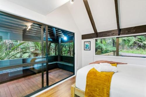 奥克兰A 1BR slice of Titirangi Heaven - WiFi - Netflix的一间卧室设有一张大床和大窗户