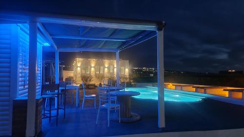 伊亚玛勒诺斯特三托公寓式酒店的一个带酒吧的庭院和一个夜间游泳池